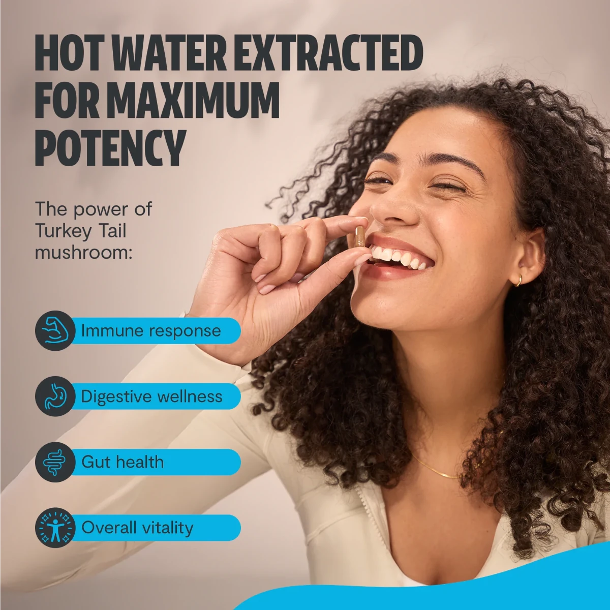 Smiling woman holding a capsule: FreshCap Mushrooms Turkey Tail Capsules hot water extracted for immunity and gut health