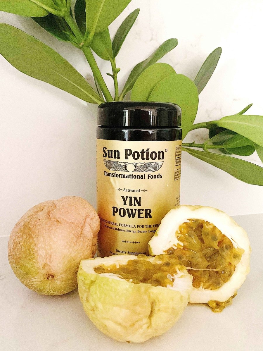 Sun Potion Yin Power jar beside green leaves and a sliced passion fruit